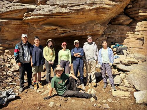 Group of people standing in front of large rock formations