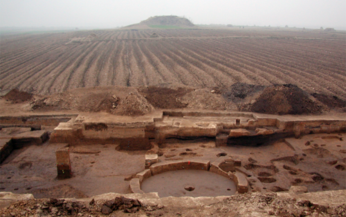 Asian excavation site with farm feilds in the background